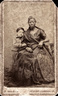 Retrato de Autusto Gomes Leal e da ama de leite Mônica. Cartão de visita de João Ferreira Villela, c.1860. <br/></br> Palavras-chave: Ama de leite. Escravidão. Criança. Amamentação.
