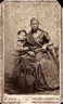 Retrato de Autusto Gomes Leal e da ama de leite Mnica. Carto de visita de Joo Ferreira Villela, c.1860. <br/></br> Palavras-chave: Ama de leite. Escravido. Criana. Amamentao.