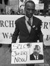 11 de janeiro de 2007 - Poydras Street, New Orleans, LA. nos Estados Unidos. "Silence is Violence. Protest against the rise in violent crime." <br/> <br/> "Silncio  violncia. Protesto contra o aumento da violncia e do crime" <br/> <br/> Na imagem, rapaz parecido com Martim Luther King com um cartaz que traz uma foto de King com os dizeres: "Justia Agora".  <br/> <br/> Palavras-chave:direito, cidadania, movimentos sociais, classes sociais, protesto.