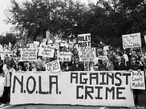 11 de janeiro de 2007 - Poydras Street, New Orleans, LA. nos Estados Unidos. "Silence is Violence. Protest against the rise in violent crime." <br/> <br/> "Silncio  violncia. Protesto contra o aumento da violncia e do crime" <br/> <br/> Na imagem passeata de manifestantes com os seguintes dizeres:"Nova Orleans contra o crime", "vocs vivem, ns morremos". <br/> <br/> Palavras-chave:direito, cidadania, movimentos sociais, classes sociais, protesto, violncia.