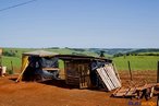 Construes rsticas tendo o latifndio ao fundo <br/> Detalhe de acampamento do MST s margens de grandes latifndios de soja - 2008, na luta por assentamentos, reforma agrria e transformaes sociais. <br/> H 25 anos atrs, em Cascavel (PR), surgiu o MST unindo posseiros, atingidos por barragens, migrantes, meeiros, parceiros e pequenos agricultores. Desde sua fundao, o Movimento Sem Terra se organiza em torno de trs objetivos principais: Lutar pela terra; Lutar por Reforma Agrria; Lutar por uma sociedade mais justa e fraterna. <br/> <br/> Palavras-chave: Movimentos sociais, MST, acampamento, assentamento, direito, reforma agrria, trabalhadores rurais, camponeses, democracia, funo social da terra, cidadania, movimentos agrrios no Brasil.