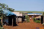 Barracas no acampamento tendo o latifndio ao fundo <br/> Detalhe de acampamento do MST s margens de grandes latifndios de soja - 2008, na luta por assentamentos, reforma agrria e transformaes sociais. <br/> H 25 anos atrs, em Cascavel (PR), surgiu o MST unindo posseiros, atingidos por barragens, migrantes, meeiros, parceiros e pequenos agricultores. Desde sua fundao, o Movimento Sem Terra se organiza em torno de trs objetivos principais: Lutar pela terra; Lutar por Reforma Agrria; Lutar por uma sociedade mais justa e fraterna. <br/> <br/> Palavras-chave: Movimentos sociais, MST, acampamento, assentamento, direito, reforma agrria, trabalhadores rurais, camponeses, democracia, funo social da terra, cidadania, movimentos agrrios no Brasil.