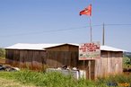 Nos acampamentos do MST, a Escola Itinerante  uma das primeiras construes a serem levantadas, como um marco do local. Na fotografia, sua estrutura e cobertura de telhas, diferente da lona das barracas do acampamento. Aos desafios tpicos de qualquer escola, soma-se a necessidade de adaptao s constantes mudanas de localidade.  Detalhe de acampamento do MST s margens de grandes latifndios de soja - 2008, na luta por assentamentos, reforma agrria e transformaes sociais.  H 25 anos atrs, em Cascavel (PR), surgiu o MST unindo posseiros, atingidos por barragens, migrantes, meeiros, parceiros e pequenos agricultores. Desde sua fundao, o Movimento Sem Terra se organiza em torno de trs objetivos principais: Lutar pela terra; Lutar por Reforma Agrria; Lutar por uma sociedade mais justa e fraterna. <br/> <br/> Palavras-chave: Movimentos sociais, MST, acampamento, assentamento, direito, reforma agrria, trabalhadores rurais, camponeses, democracia, funo social da terra, cidadania, movimentos agrrios no Brasil, instituio escolar.